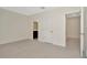 A bedroom with light gray carpet features two doors, one leading to a bathroom at 2949 Suncoast Plains Dr, Odessa, FL 33556