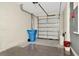 Clean two car garage with a blue trash can at 2949 Suncoast Plains Dr, Odessa, FL 33556