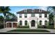 Charming two-story home showcasing a brick facade, arched windows, and a well-manicured front lawn at 3021 W Lawn Ave, Tampa, FL 33611