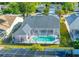 An aerial view of home with a screened in pool enclosure and well-maintained landscaping at 3051 Jodi Ln, Palm Harbor, FL 34684