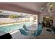 Inviting covered patio with a ceiling fan overlooking the screened-in pool area, perfect for outdoor dining at 3051 Jodi Ln, Palm Harbor, FL 34684