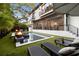 Backyard boasts a pool, spa, and lounge chairs, enhanced by an outdoor fire pit and artificial grass at 3105 S Schiller St, Tampa, FL 33629