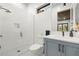 Modern bathroom featuring a glass-enclosed shower, skylight, and stylish blue vanity at 3105 S Schiller St, Tampa, FL 33629