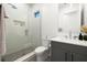 Modern bathroom with glass shower, gray vanity, decorative wall tiles and stone shower floor at 3105 S Schiller St, Tampa, FL 33629