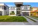 Beautiful modern home featuring clean lines, a manicured lawn, balcony, and a two-car garage at 3105 S Schiller St, Tampa, FL 33629