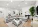 Spacious living room featuring a large gray sectional sofa, modern decor, and light hardwood flooring at 3105 S Schiller St, Tampa, FL 33629