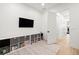 Bright playroom featuring built-in shelving, gray storage bins, a wall-mounted TV, and a stylish patterned rug at 3105 S Schiller St, Tampa, FL 33629