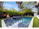 Backyard oasis with a pool, spa, fire bowls, and lush green landscaping at 3105 S Schiller St, Tampa, FL 33629