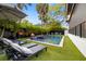 Backyard with a pool, fire bowls, lounge chairs, and lush tropical landscaping at 3105 S Schiller St, Tampa, FL 33629