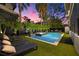Backyard pool and jacuzzi surrounded by lush, tropical landscaping and elegant lounge furniture at sunset at 3105 S Schiller St, Tampa, FL 33629