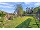 This backyard features a large grassy area, and fire pit, excellent for outdoor activities and relaxation at 3208 Stevenson St, Plant City, FL 33566