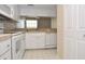 Bright kitchen featuring white appliances, tile countertops, and ample cabinet space at 3358 Mermoor Dr # 2106, Palm Harbor, FL 34685