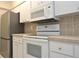 Modern kitchen featuring white cabinets, stainless steel refrigerator, and appliances at 3358 Mermoor Dr # 2106, Palm Harbor, FL 34685