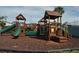 A well-maintained community playground features wooden structures, slides, and climbing areas for children at 3358 Mermoor Dr # 2106, Palm Harbor, FL 34685