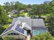 Aerial view of a residence in a verdant, tree-filled neighborhood with a screened-in pool and solar panels at 3612 Sugar Loaf Ln, Valrico, FL 33596