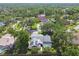 Aerial view of a home with a screened-in pool surrounded by lush greenery in a peaceful neighborhood at 3612 Sugar Loaf Ln, Valrico, FL 33596