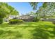 Expansive backyard featuring lush green grass, mature trees, landscaping and screened in pool at 3612 Sugar Loaf Ln, Valrico, FL 33596