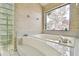 Bathroom featuring a tub, tile surround, and glass block window at 3612 Sugar Loaf Ln, Valrico, FL 33596