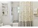 Bathroom featuring white tiling in shower/tub with neutral colored shower curtain and shelving at 3612 Sugar Loaf Ln, Valrico, FL 33596