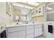 Bathroom with double sinks, vanity, glass block window, and updated fixtures at 3612 Sugar Loaf Ln, Valrico, FL 33596