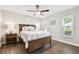 Bedroom features a ceiling fan, a wood bed frame, laminate wood flooring, and natural lighting at 3612 Sugar Loaf Ln, Valrico, FL 33596