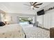 Bright bedroom featuring a ceiling fan, TV, large bed, and sliding glass doors to the pool at 3612 Sugar Loaf Ln, Valrico, FL 33596