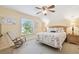 Bedroom with wood floors, a ceiling fan, and a window overlooking the landscaped yard at 3612 Sugar Loaf Ln, Valrico, FL 33596