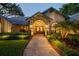 Inviting front entrance featuring a brick archway, double doors, and well-manicured landscaping at 3612 Sugar Loaf Ln, Valrico, FL 33596