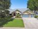 Attractive single-story home featuring a well-manicured lawn, mature trees, and a three-car garage at 3612 Sugar Loaf Ln, Valrico, FL 33596