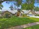 Charming single-story home with manicured lawn, mature trees, and a welcoming entrance at 3612 Sugar Loaf Ln, Valrico, FL 33596