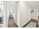 Hallway view with wood laminate flooring and white trim looking into a bedroom and living area at 3612 Sugar Loaf Ln, Valrico, FL 33596