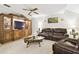 Living room with a brown leather sofa, glass coffee table and entertainment center at 3612 Sugar Loaf Ln, Valrico, FL 33596