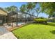 Beautiful outdoor screened-in pool and garden area with lush green lawn and mature landscaping at 3612 Sugar Loaf Ln, Valrico, FL 33596