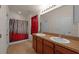 Bathroom featuring double sinks, a tile floor, a shower and a red and black shower curtain at 5714 Kingletsound Pl, Lithia, FL 33547
