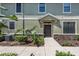 Front entrance of a two story home featuring a black door, manicured landscaping, and neutral colors at 5714 Kingletsound Pl, Lithia, FL 33547