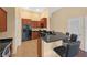 Kitchen featuring wood cabinets, a breakfast bar with seating, a black refrigerator, and tile flooring at 5714 Kingletsound Pl, Lithia, FL 33547