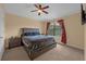 Neutral bedroom featuring a ceiling fan, carpeting, a window, and a gray upholstered bed frame at 5714 Kingletsound Pl, Lithia, FL 33547