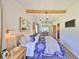 Charming bedroom with a chandelier, wooden beam, and a beautiful, patterned blue duvet cover at 609 4Th Sw Ave, Ruskin, FL 33570