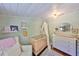 Cozy Bedroom featuring a crib with canopy, charming decor, and light green wooden plank walls at 609 4Th Sw Ave, Ruskin, FL 33570