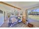 Bright bedroom with wood beam, large window view and comfortable seating area, with a patterned duvet at 609 4Th Sw Ave, Ruskin, FL 33570