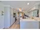 Charming kitchen features white cabinets, quartz countertops, stainless appliances, and a decorative rug on wood floors at 609 4Th Sw Ave, Ruskin, FL 33570