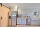 Modern kitchen featuring gray cabinets, stainless steel appliances, quartz counters, and a sliding barn door at 609 4Th Sw Ave, Ruskin, FL 33570