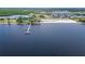 A wide-angle view captures a pier extending into the bay near a neighborhood and beach under a partly cloudy sky at 803 Bahia Del Sol Dr # 66, Ruskin, FL 33570
