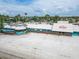 Aerial view of a beach front restaurant surrounded by sand, palm trees, and umbrellas under a partly cloudy sky at 803 Bahia Del Sol Dr # 66, Ruskin, FL 33570