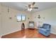 Sunlit bedroom features hardwood floors, ceiling fan, chair and beach-themed decor at 803 Bahia Del Sol Dr # 66, Ruskin, FL 33570