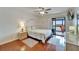 Bedroom with wood floors, balcony access offering a view, ceiling fan, and dresser with decor at 803 Bahia Del Sol Dr # 66, Ruskin, FL 33570