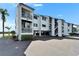 Three-story condo complex with covered parking and palm trees in a landscaped yard at 803 Bahia Del Sol Dr # 66, Ruskin, FL 33570