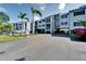 Multi-story condo building with covered parking, palm trees, and an American flag at 803 Bahia Del Sol Dr # 66, Ruskin, FL 33570
