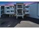 Multi-story condo building with covered parking, palm trees, and an American flag at 803 Bahia Del Sol Dr # 66, Ruskin, FL 33570