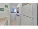 A well-lit galley kitchen features a full size white refrigerator and storage cabinets at 803 Bahia Del Sol Dr # 66, Ruskin, FL 33570